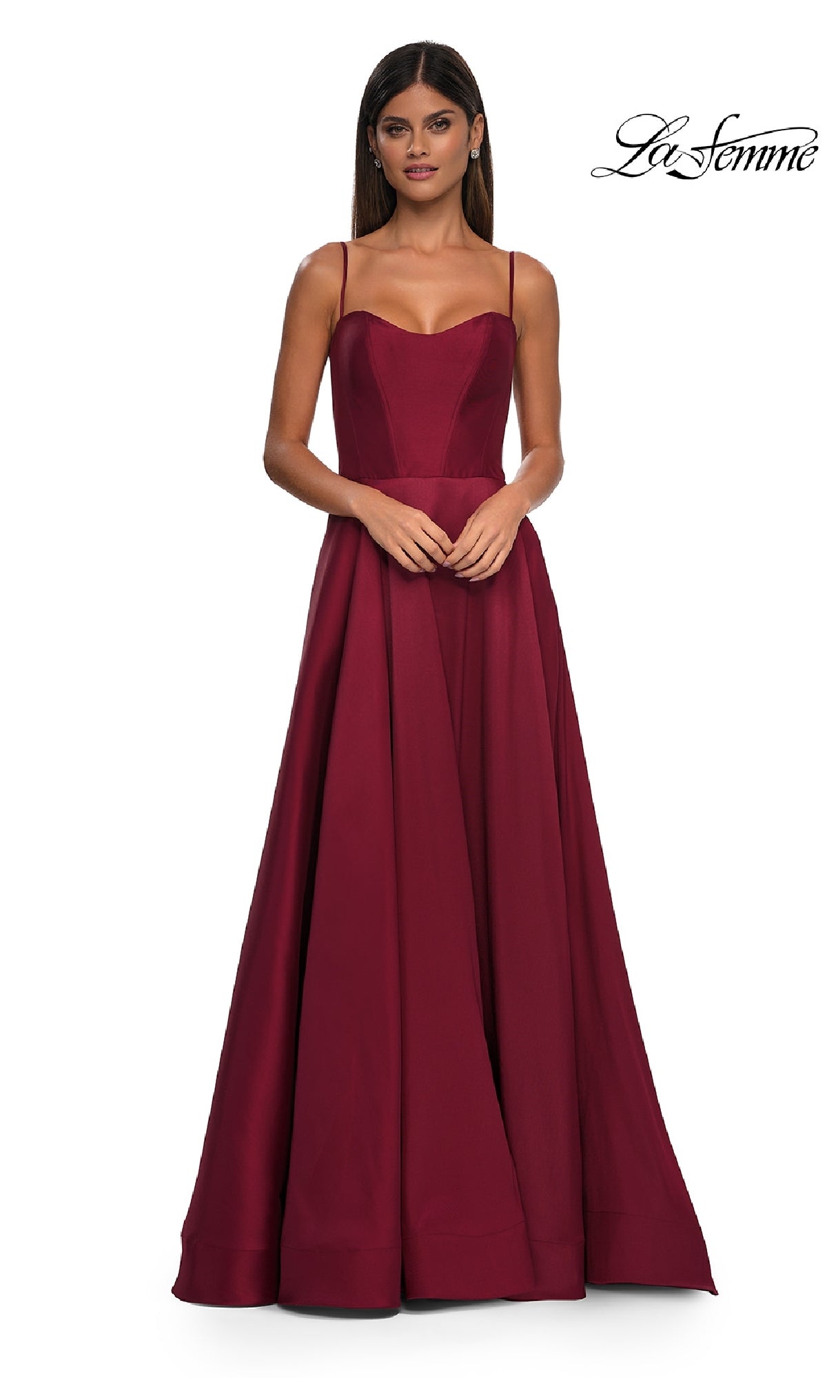 A woman in the Sheer-Corset Long A-Line Prom Gown (La Femme 32670), a sleeveless, floor-length burgundy dress with thin straps, poses against a plain white background.